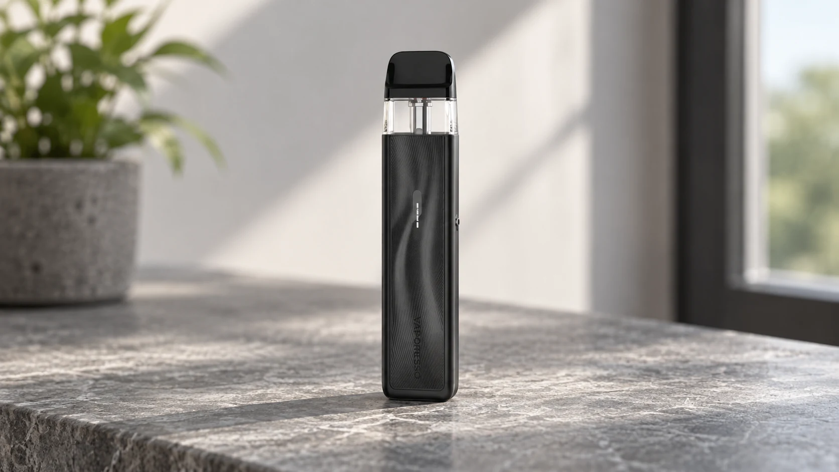 Black Vaporesso XROS 5 Mini refillable pod vape standing upright on a stone countertop in soft window light.