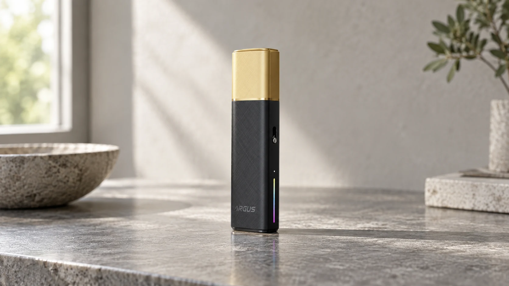 VOOPOO ARGUS Klyc pod kit standing upright on a stone countertop in soft natural light, with a black body, gold protective cap and slim colored indicator strip.